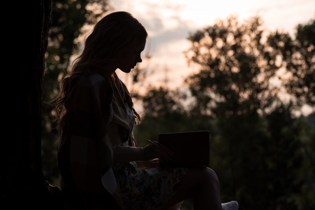 woman writing in journal to overcome postpartum depression