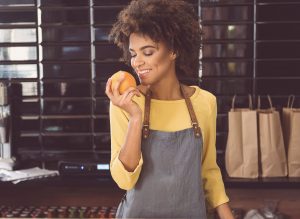 black woman smelling tangerine to press tangerine essential oil
